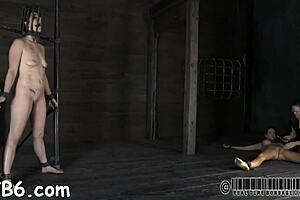 in a dimly lit room, a submissive endures extreme sadomasochistic torment