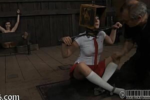 Woman performs emotional striptease inside cage, clothes ripped