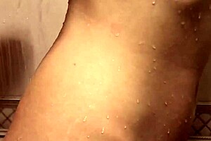 Horny lesbians finger each other to orgasm in a steamy bathroom.