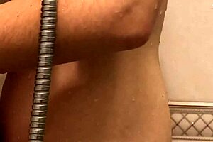 Horny lesbians finger each other to orgasm in a steamy bathroom.