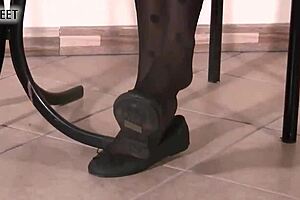 Blonde ballerina in black dotted stockings teases her feet