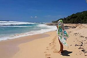 My sandy ass shows red butt plug at beach.