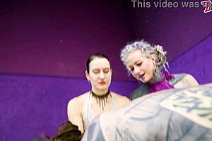 Heavy tattooed sub pegged by two dominas