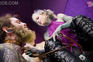 Heavy tattooed sub pegged by two dominas