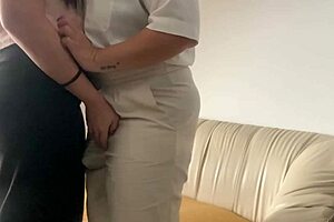 Latina lesbians fuck on the sofa using a strapon and playing with big natural tits