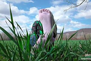 Goddess feet in white socks and jeans on spring grass