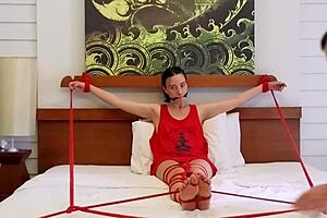 Sofi gets tied up in red ropes on the bed, part 2