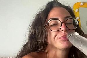 This horny tattooed brunette masturbates with sex toys, glasses on, reaching orgasm.