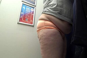 Big-ass curvy milf changes clothes in satin panties, watched by the fitting room camera in this amateur fetish.