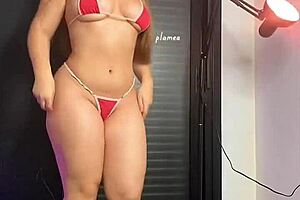 blonde woman poses in a micro bikini with high heels