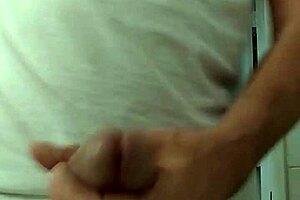 A guy strokes his cock until he cums.