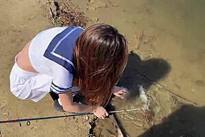 Young angler girl fishes after school in uniform.