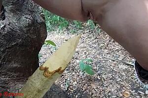 Watch this perverted slut squirt piss from a wooden stake in the forest?