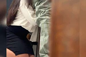 una maestra y su alumno en el salon de clases lo manda a llamar y los graban detras de la puerta