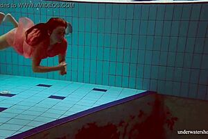 hot deniska strips underwater in the pool, her shaved body glistening naked