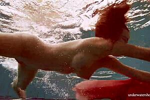 hot deniska strips underwater in the pool, her shaved body glistening naked