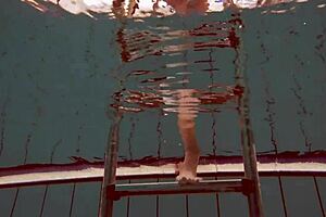 hot deniska strips underwater in the pool, her shaved body glistening naked