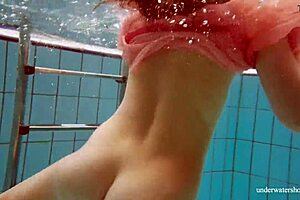 hot deniska strips underwater in the pool, her shaved body glistening naked