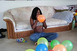 ebony babe with big tits blows up balloons in french fetish play session