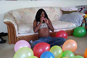ebony babe with big tits blows up balloons in french fetish play session