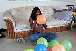 ebony babe with big tits blows up balloons in french fetish play session