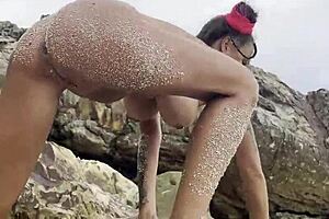 Monika Fox pleasures shaved pussy with dildo on sunny beach